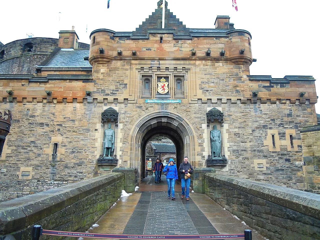 The gatehouse entrance to Edinburgh Castle from the Esplanade, with the royal arms above the arch and a statue in a niche on each side