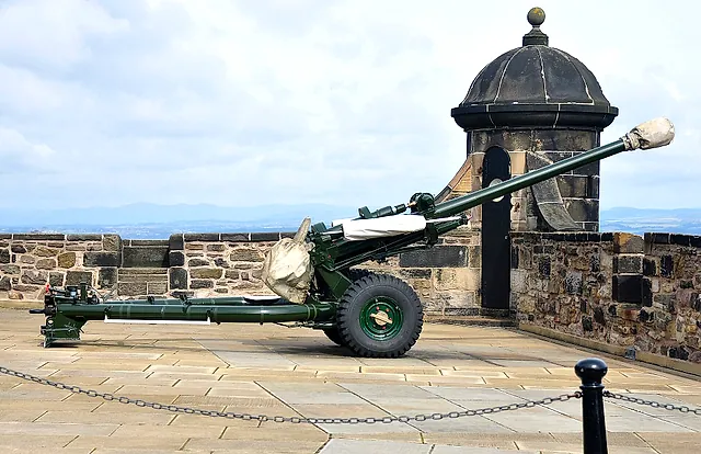 The One O'Clock Gun, a green field gun pointing over the ramparts next to a stone sentry box on the castle wall